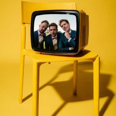 Zanadu Coverband München – die Bandmitglieder als Köpfe in einem gelben Retro-Fernseher